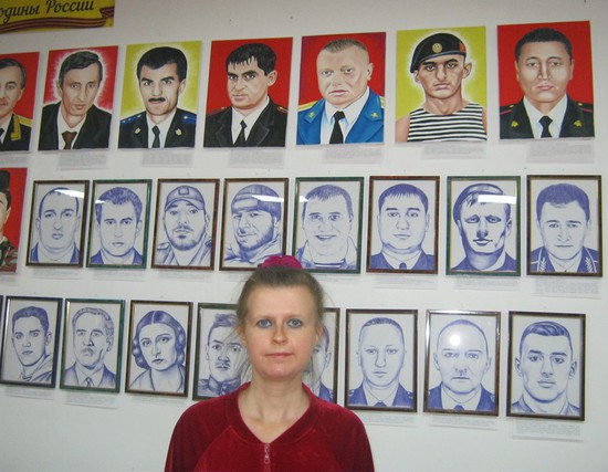 Художница на фоне портретов выставки. ELENA KIRMIZI NAR