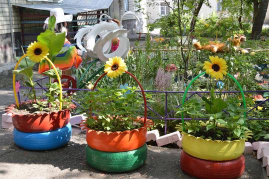 Вход в подъезд украсили декоративные подсолнухи  в двухъярусных вазонах., город - цветущий сад