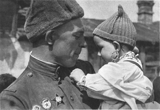 Советский солдат с чешским ребенком на руках. Малыш рассматривает орден Славы на груди бойца. Автор А. Холубова
