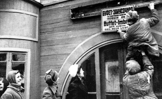 В Кисловодске после оккупации снимают немецкую табличку со здания закусочной, январь 1943 г.
