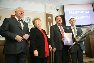 Слева направо: Ю. Белый, Л. Кузякова, И. Ковалев поздравляют  «УМНИКа» И. Закорецкого (СтГМУ), конференция, УМНИК