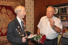 Подполковник в отставке Александр Бирюков  вручает члену ветеранской организации памятный знак. 