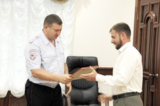 Алексей Голощапов получает благодарность  из рук полковника полиции Ивана Уско.