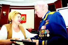 Татьяна Середа вручает памятный знак администрации города генерал-майору авиации Борису Аверину.