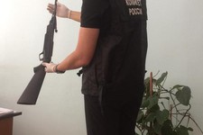 На фото СУ СКР по СК: следователь осматривает пневматическую винтовку.