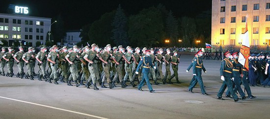 На репетиции военные маршируют в масках.